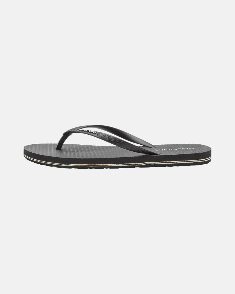 The Women's Volcomotion Womens sandal by Volcom features thin black straps and a textured sole, shown from the side on a white background—ideal for everyday comfort and classic style.