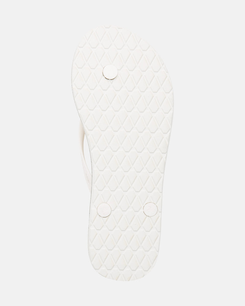The image shows the white sole of the Volcom Volcomotion Womens flip-flop, featuring a textured diamond pattern and three round plugs on the bottom.
