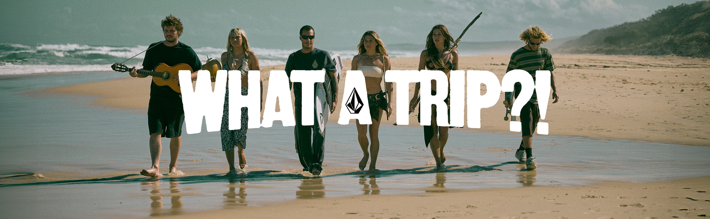 Group of people on a beach with 'WHAT A TRIP?!' text overlay