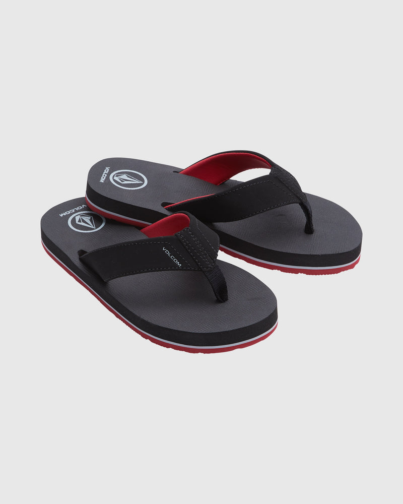 The Volcom Kids' Victor Big Youth sandals feature a water-friendly footbed, sporty black and red design, textured soles, and a logo on the footbed—perfect flip-flops for everyday adventures. Displayed on a light gray background.