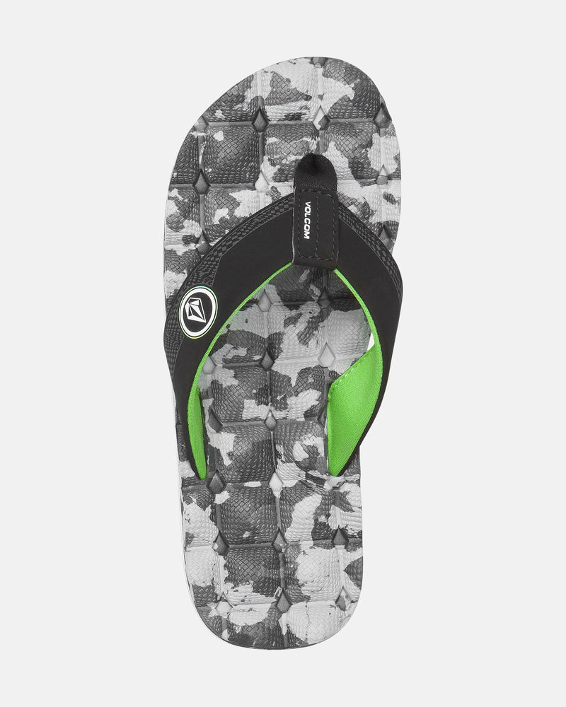 The Volcom Kids' Recliner 2 Big Youth sandal features a black and gray camo-patterned sole, comfort foam footbed, black straps with green lining, and a Volcom logo on the strap, displayed on a white background.