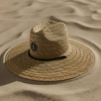 Beige straw hat with a logo on sand