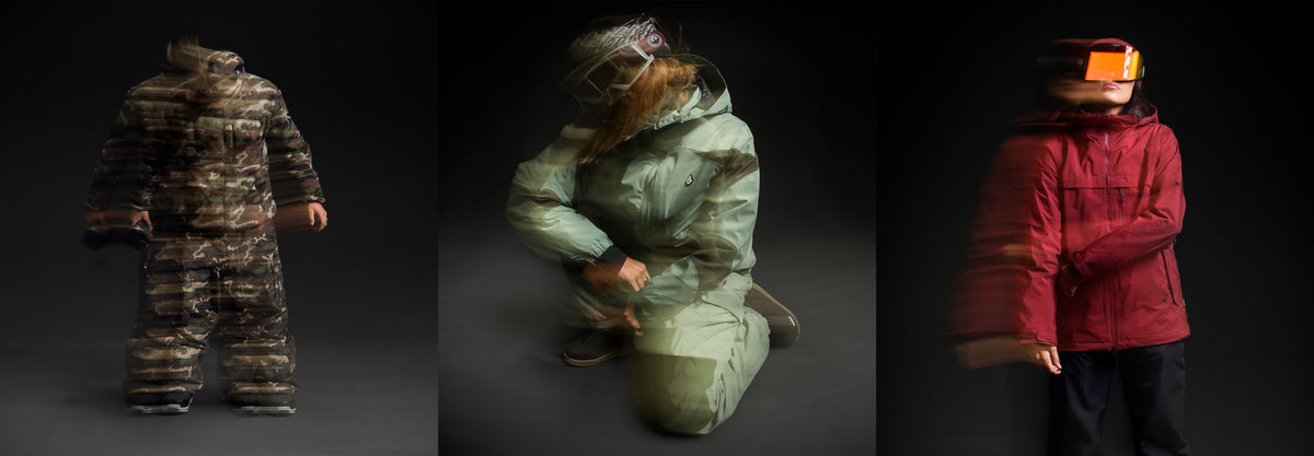 Three views of a thick, insulated winter suit or snowsuit shown on a dark studio background: a full front view in a dark camouflage pattern, a kneeling back view in olive green, and a side view worn by a person in a red jacket with a bright orange visor.