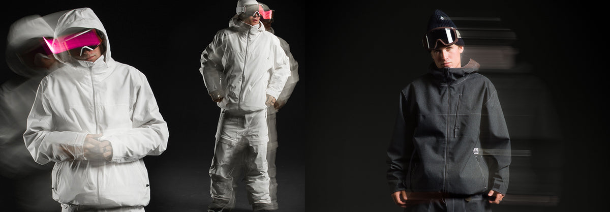 Three models wearing winter sports gear are shown against a dark studio background. On the left, a model wears a white hooded jacket and matching pants with a bright pink visor.